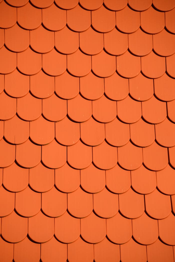 portfolio-01 Bright orange roof tiles arranged in a seamless repetitive pattern, perfect for backgrounds and designs.